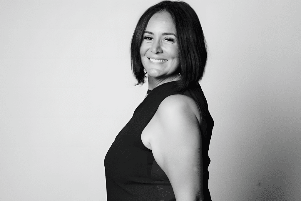 Femme souriante : Portrait noir et blanc élégant Portrait noir et blanc d'une femme souriante aux cheveux courts, vue de profil sur fond clair uni.